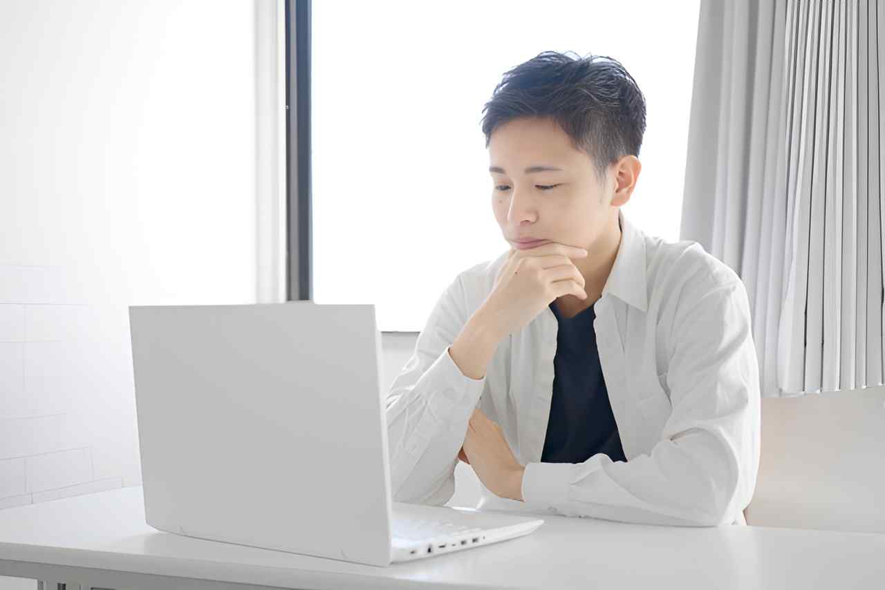 パソコンの前に座っている男性