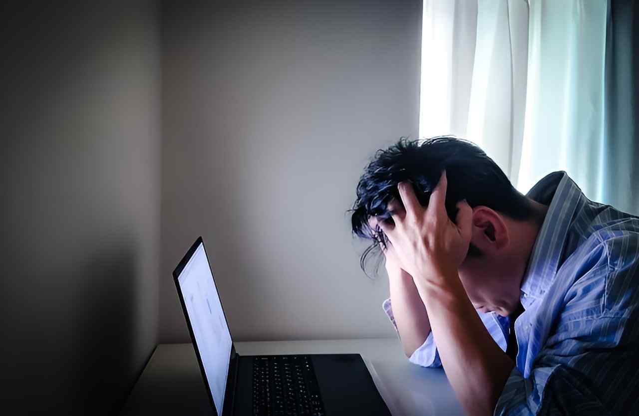 パソコンの前で頭を抱える男性